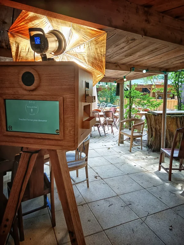 La borne finition imitation bois et son parapluie d’éclairage doré installés sous une terrasse en bois